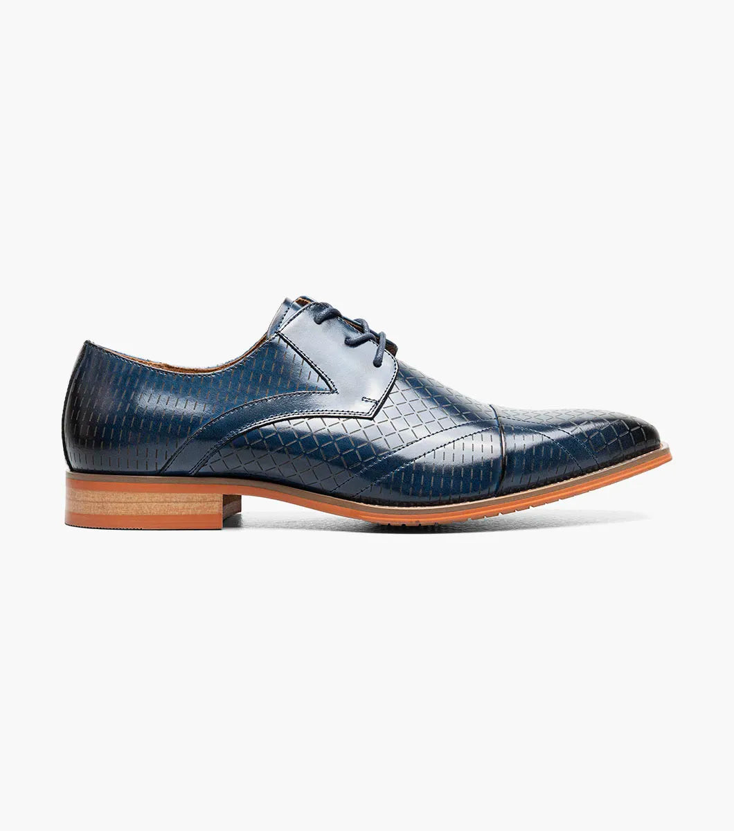 The Stacy Adams Hobson Cap Toe Oxford (25764-400) is a single blue dress shoe with a laser-etched diamond calf leather pattern, lace-up closure, brown sole, and sleek pointed toe.