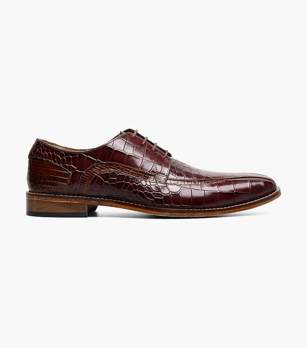 The STACY ADAMS Gabardo Bike Toe Oxford in cognac (25681-221) features a brown crocodile print leather upper, lace-up design, low heel, and genuine leather sole, shown on a white background.
