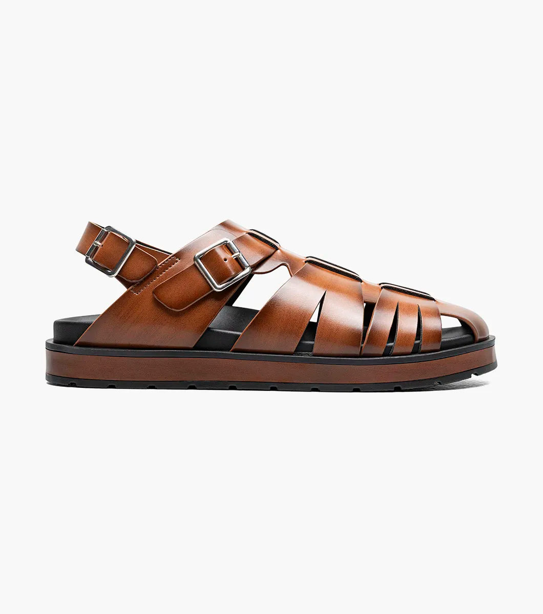 The STACY ADAMS Largo Slingback Buckle Sandal in cognac features a closed toe, woven leather upper, adjustable side buckle, and cushioned black sole—perfect men’s summer footwear. Shown here in style 25773-221 on a white background.