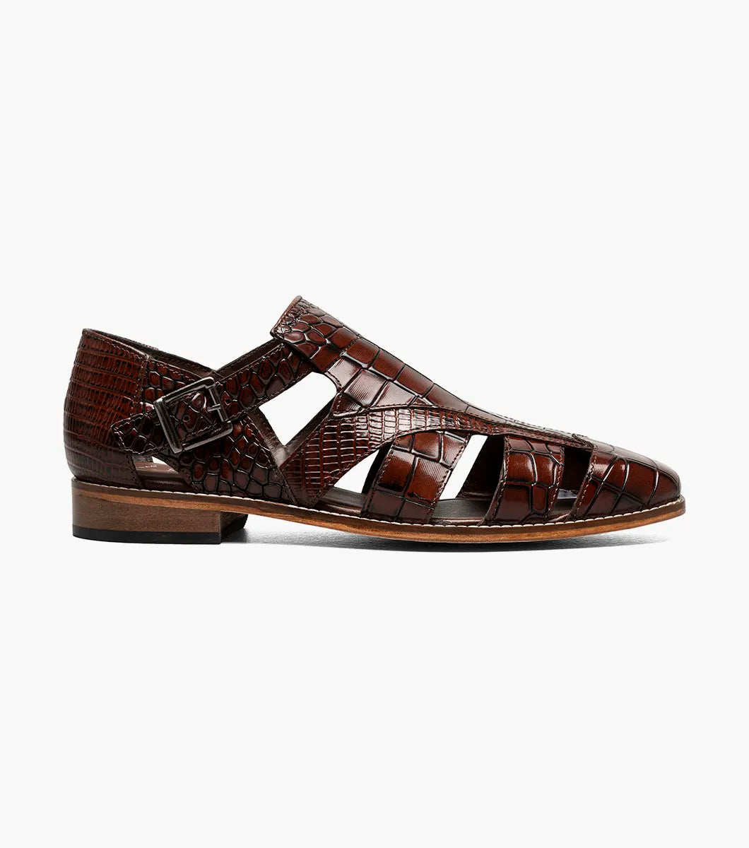The STACY ADAMS Calandro City Sandal (Cognac, 25695-221) is a brown genuine leather dress shoe with a crocodile pattern, cushioned footbed, side buckle, and closed toe, displayed on a white background.