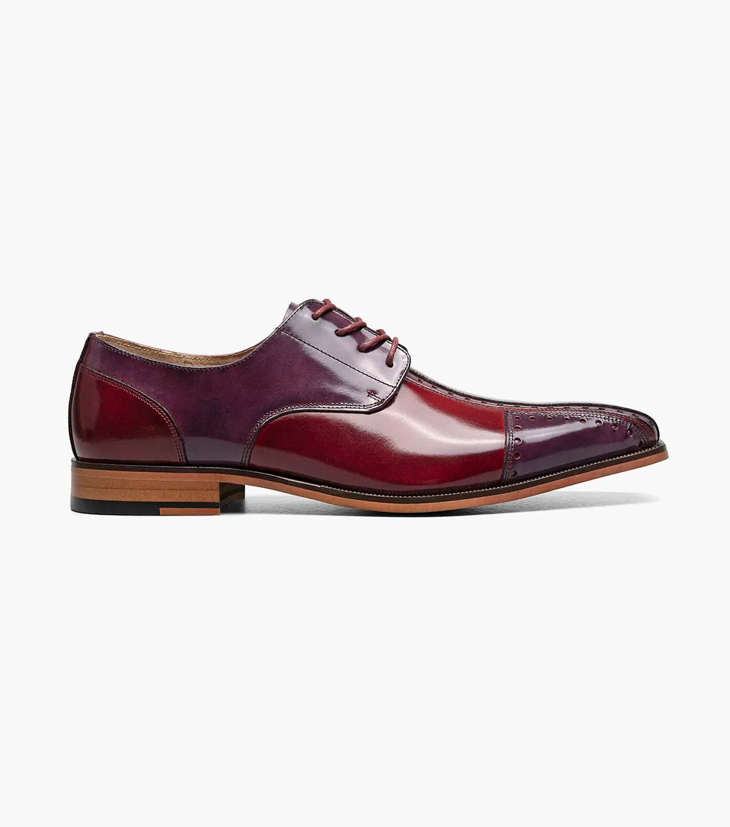 The STACY ADAMS Palmento Modified Cap Toe Oxford in Burgundy Multi (25740-641) features a polished leather upper, brogue accents, lace-up closure, Memory Foam insole, and wooden sole. Single shoe shown on white background.