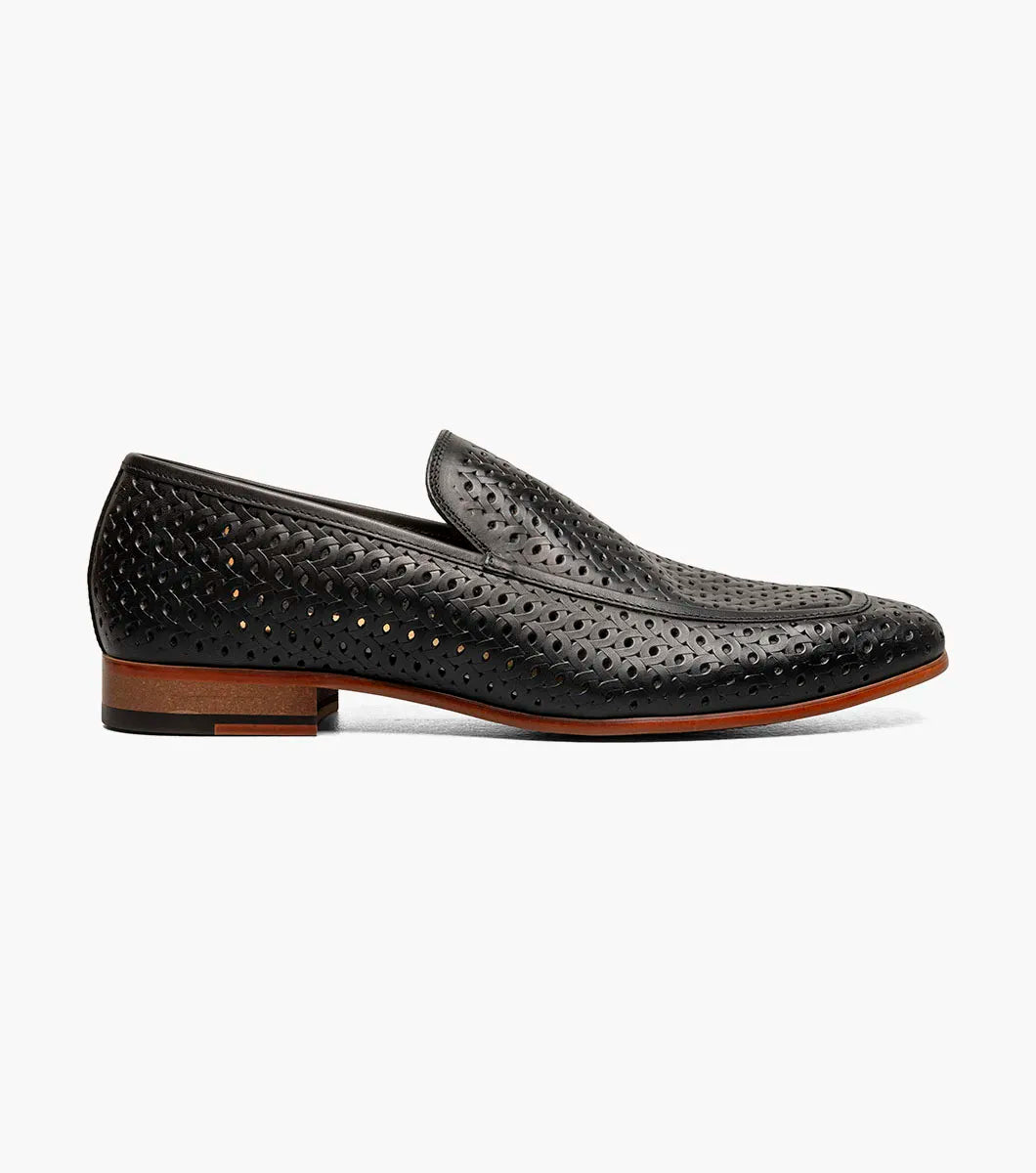 The STACY ADAMS Winden Moc Toe Perf Slip On (Black, 25645-001) features a perforated leather design, memory foam insole for comfort, low heel, and brown sole, shown on a white background.