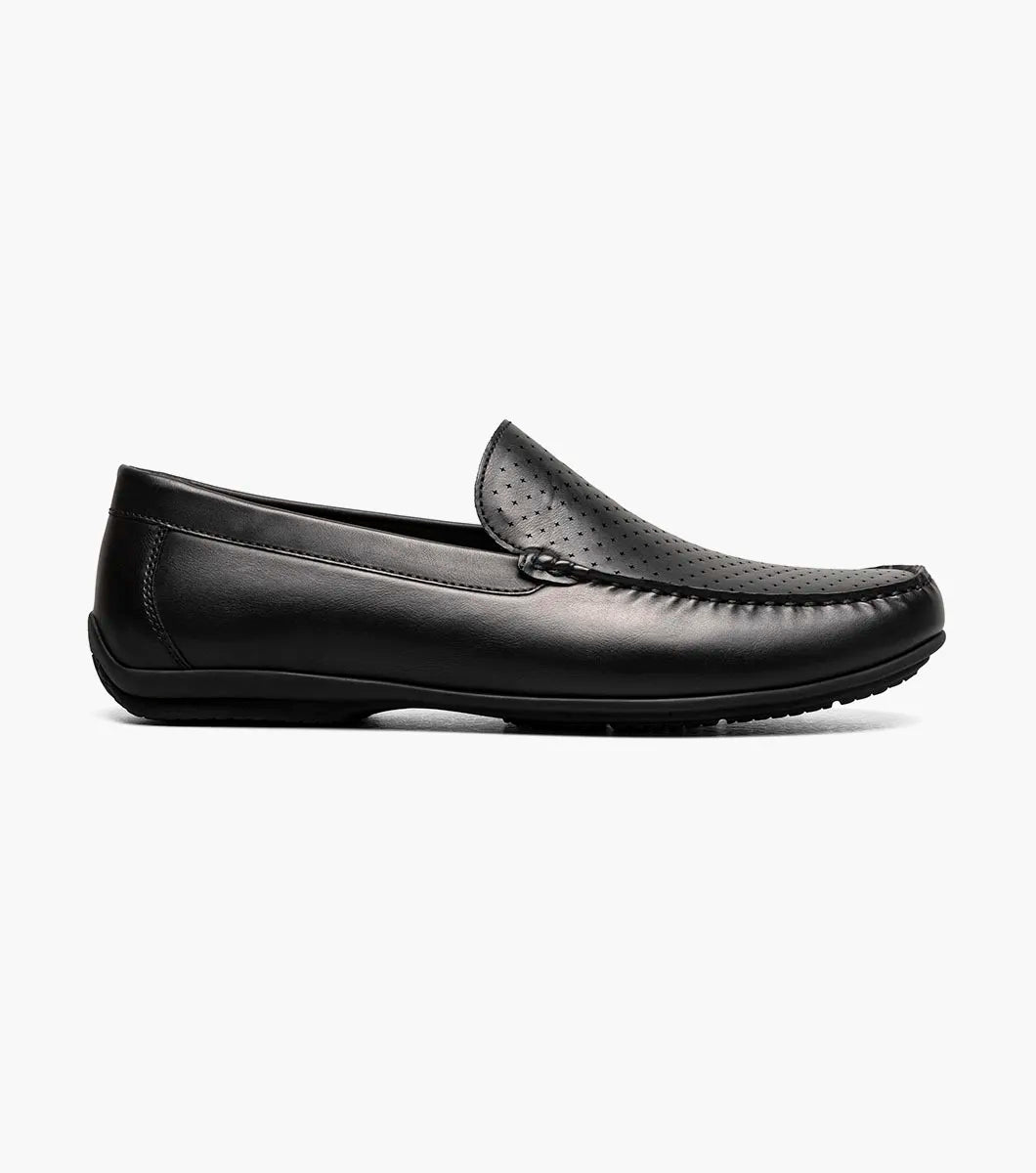 The Stacy Adams Conroy Moc Toe Perf Slip On (Black, 25702-001) features a perforated leather upper, visible stitching, low heel, striped inner lining, and cushioned footbed.