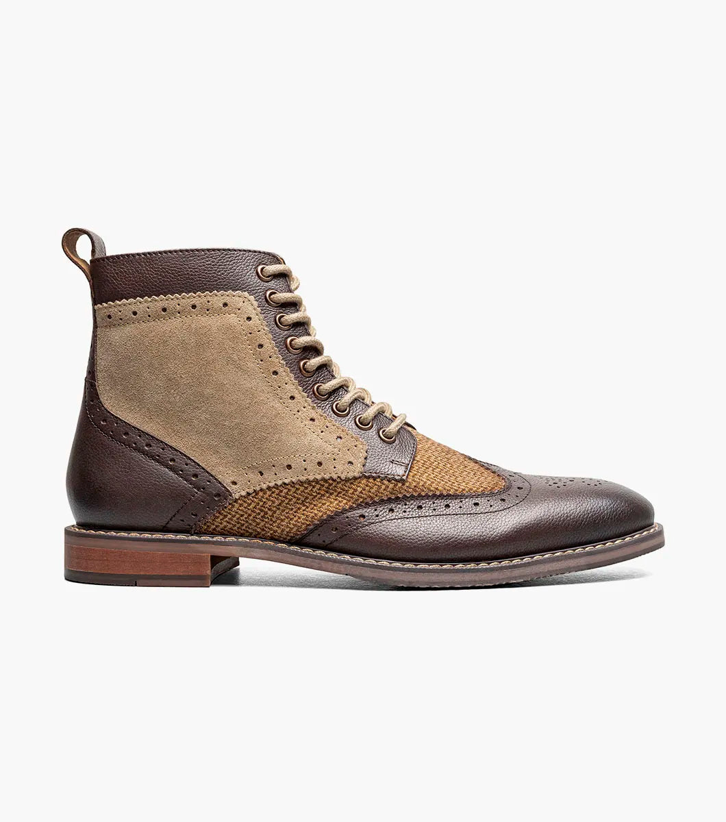 The Stacy Adams Finnegan Wingtip Lace Up Boot in Brown Tumbled (style 25427-247) features brown and tan leather suede, brogue wingtip detailing, a lace-up closure, a memory foam insole for added comfort, and a low heel, shown against a white background.
