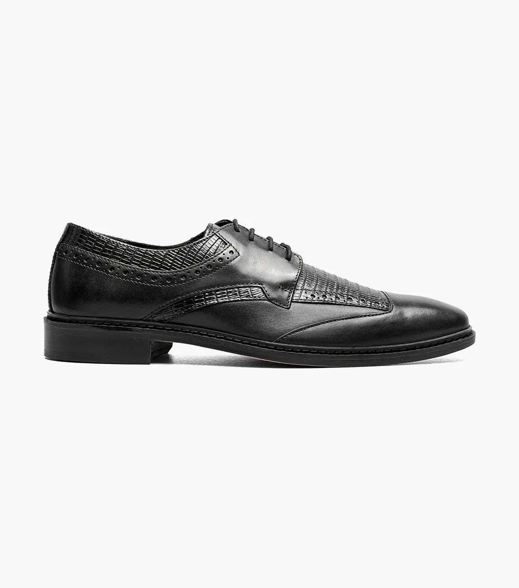 The Stacy Adams Gambetta Modified Cap Toe Oxford (25780-001) is a black leather dress shoe with textured detailing, lace-up closure, low heel, and RedZone footbed, shown on a plain white background.