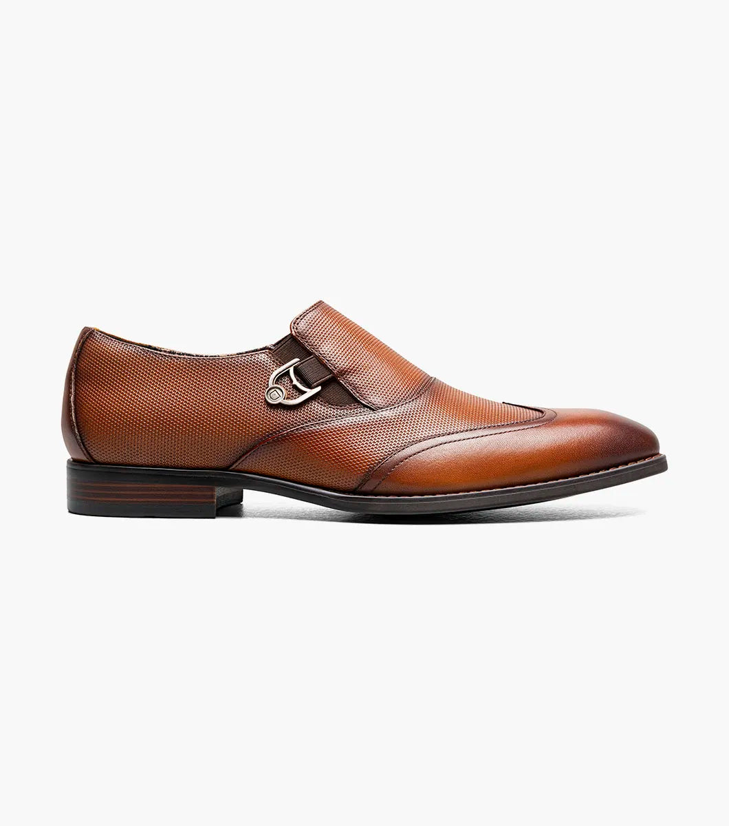 The Stacy Adams Lockwood Wingtip Ornament Slip On in Cognac features classic leather style with a textured upper, single side buckle, and low stacked heel—perfect for men seeking timeless dress shoes.