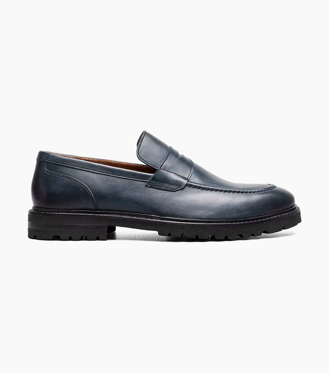 The Stacy Adams Hayes Moc Toe Penny Slip On in navy features a dark blue leather upper, textured black EVA sole, classic penny slot, subtle stitching, and a comfortable RedZone footbed.