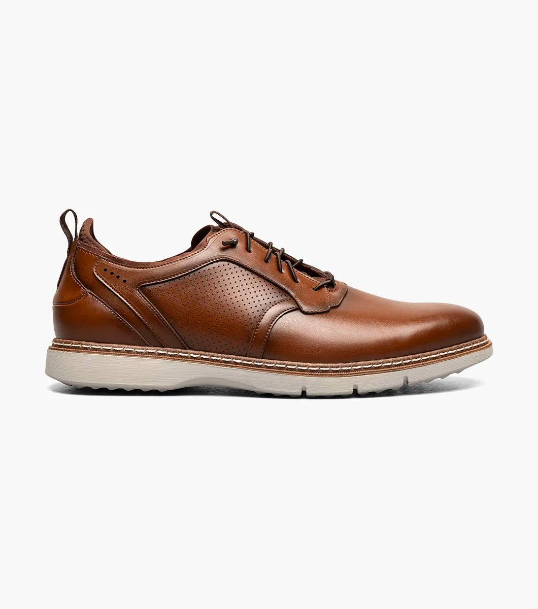 The Stacy Adams Score Plain Toe Elastic Lace Up in Cognac (21538-221) features brown leather with perforated side detailing, elastic laces, and a white rubber sole. Enhanced with a RedZone footbed for superior support and all-day comfort, this STACY ADAMS shoe is displayed against a plain white background.
