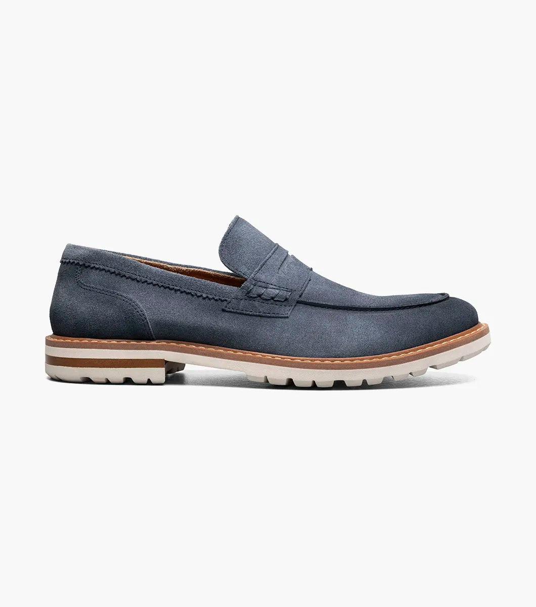 The Stacy Adams Hopkins Moc Toe Penny Slip On in navy suede features a moc toe, penny strap, white and tan rubber sole, and visible stitching, shown on a plain white background for comfort and style.