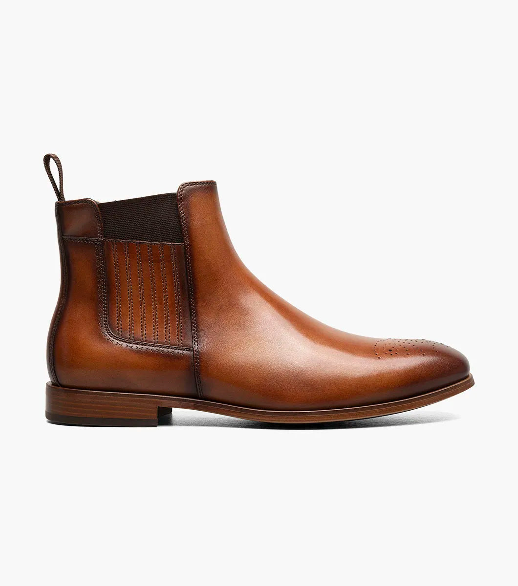 The STACY ADAMS Bradley Plain Toe Chelsea Boot in tan features anatomical arch support, elastic side panels, a pull tab, and decorative toe perforations. Displayed on a white background.