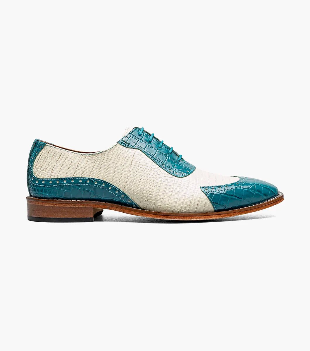 The STACY ADAMS Tarango Modified Cap Toe Oxford (25770-448) is a men's formal shoe in navy with teal, showcasing crocodile print leather and a laceless design, pictured on a plain white background.