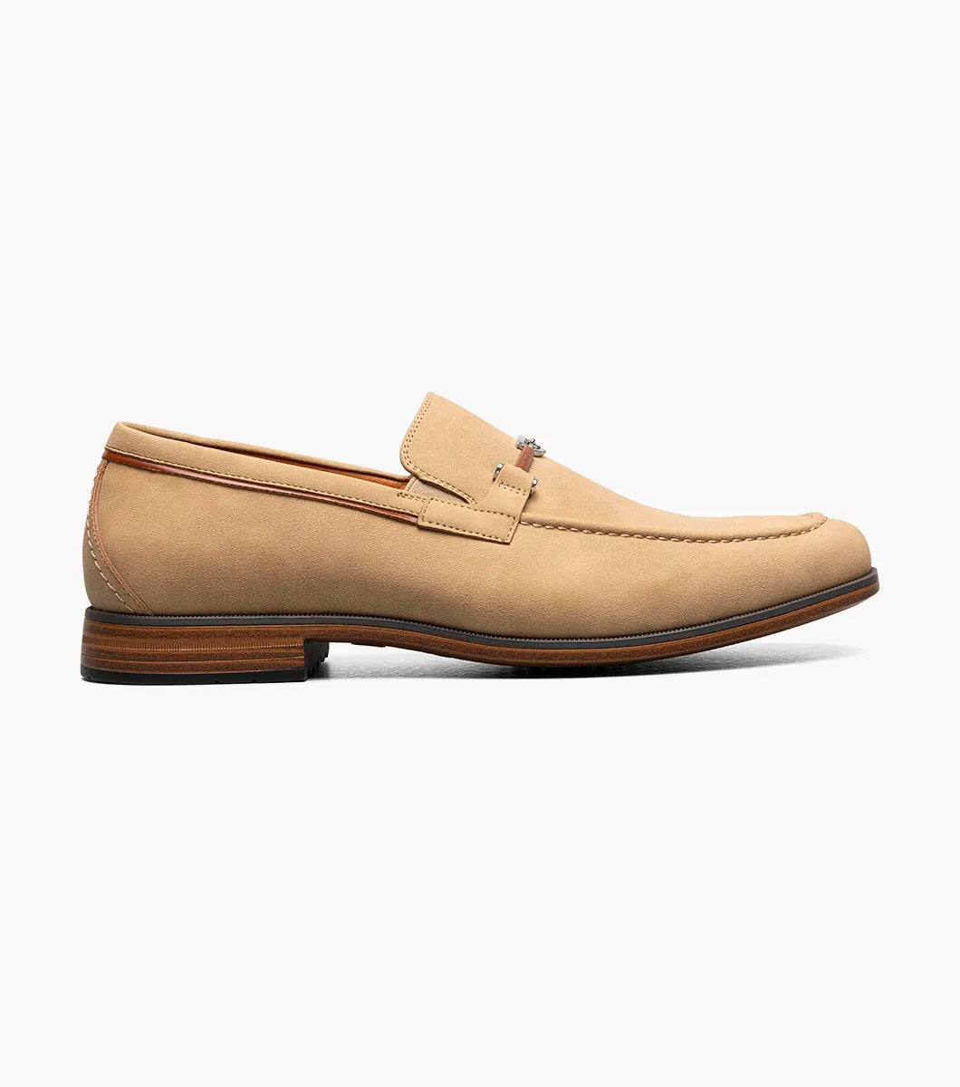The STACY ADAMS Richardson Moc Toe Bit Slip On (Khaki, 25746-274) is a men's loafer featuring a metal bit detail, low wooden heel, and cushioned RedZone footbed, displayed on a white background.
