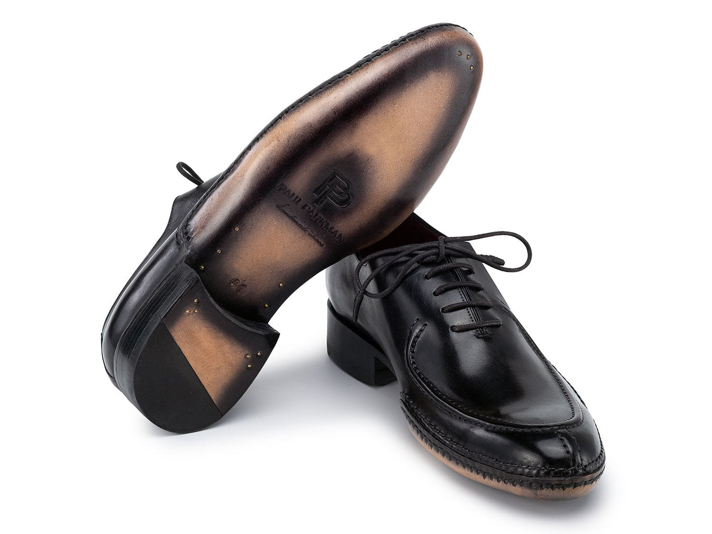 The Paul Parkman Opanka Stitched Men's Split-Toe Black Leather Oxford Shoes (054-BLK) are shown on a white background, one upright and the other leaning, both crafted from hand-painted leather with laces.