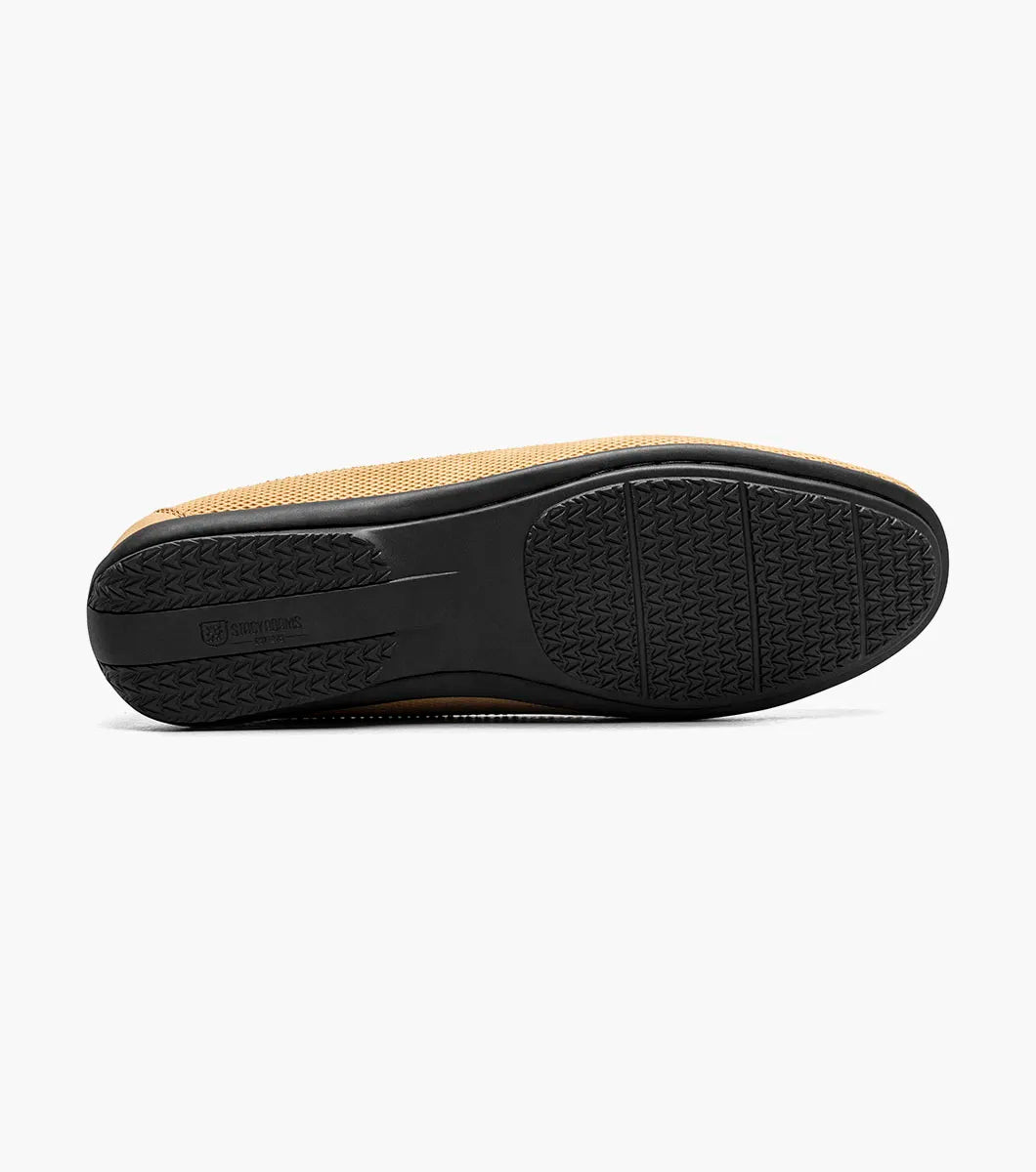 The Stacy Adams Colton Moc Toe Bit Slip On in khaki features a stitched moc toe, metal bit detail, black rubber sole, multicolored striped lining, and cushioned footbed for all-day comfort.