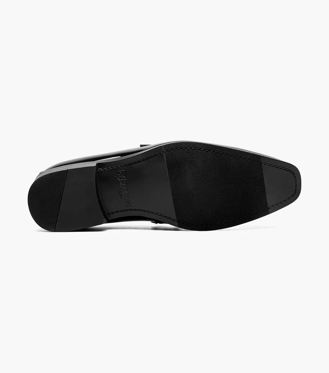 The STACY ADAMS Spratley Moc Toe Saddle Slip On in black features patent leather, a low heel, velvety strap detail, memory foam cushioning, and a slightly pointed toe, shown on a white background.