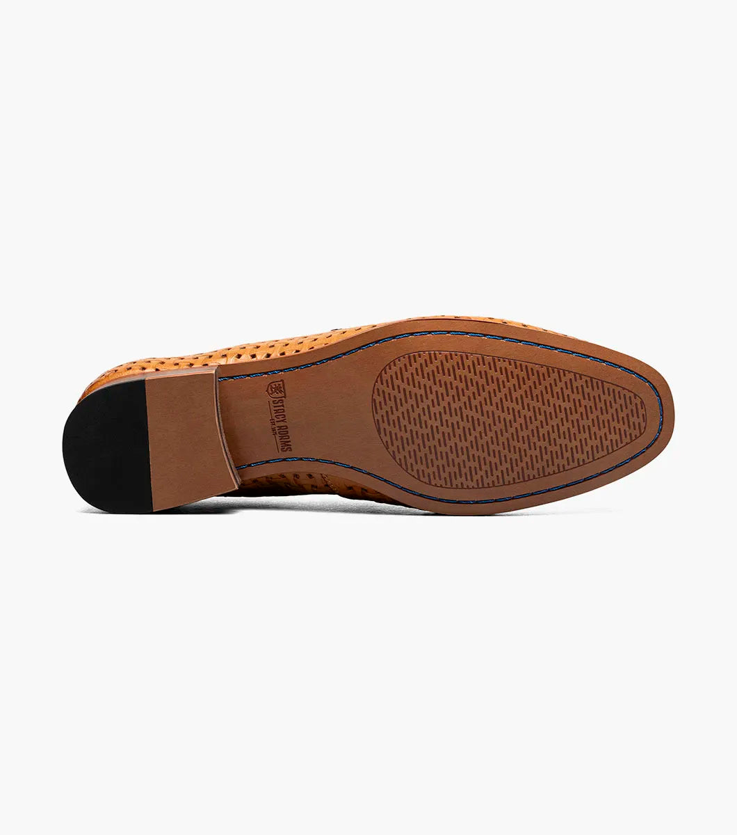 The STACY ADAMS Winstead Moc Toe Saddle Slip On in Natural features a brown woven leather upper, dark blue trim, Memory Foam insole, and low heel, displayed on a white background.