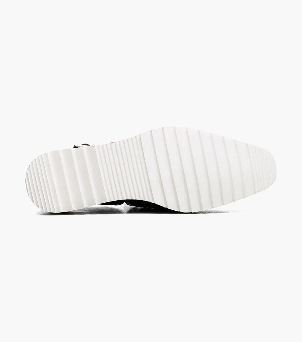 The Stacy Adams Alvarado Woven City Sandal features a black woven leather upper, buckle strap, closed toe, memory foam insole, and a white ridged sole with tan accent.