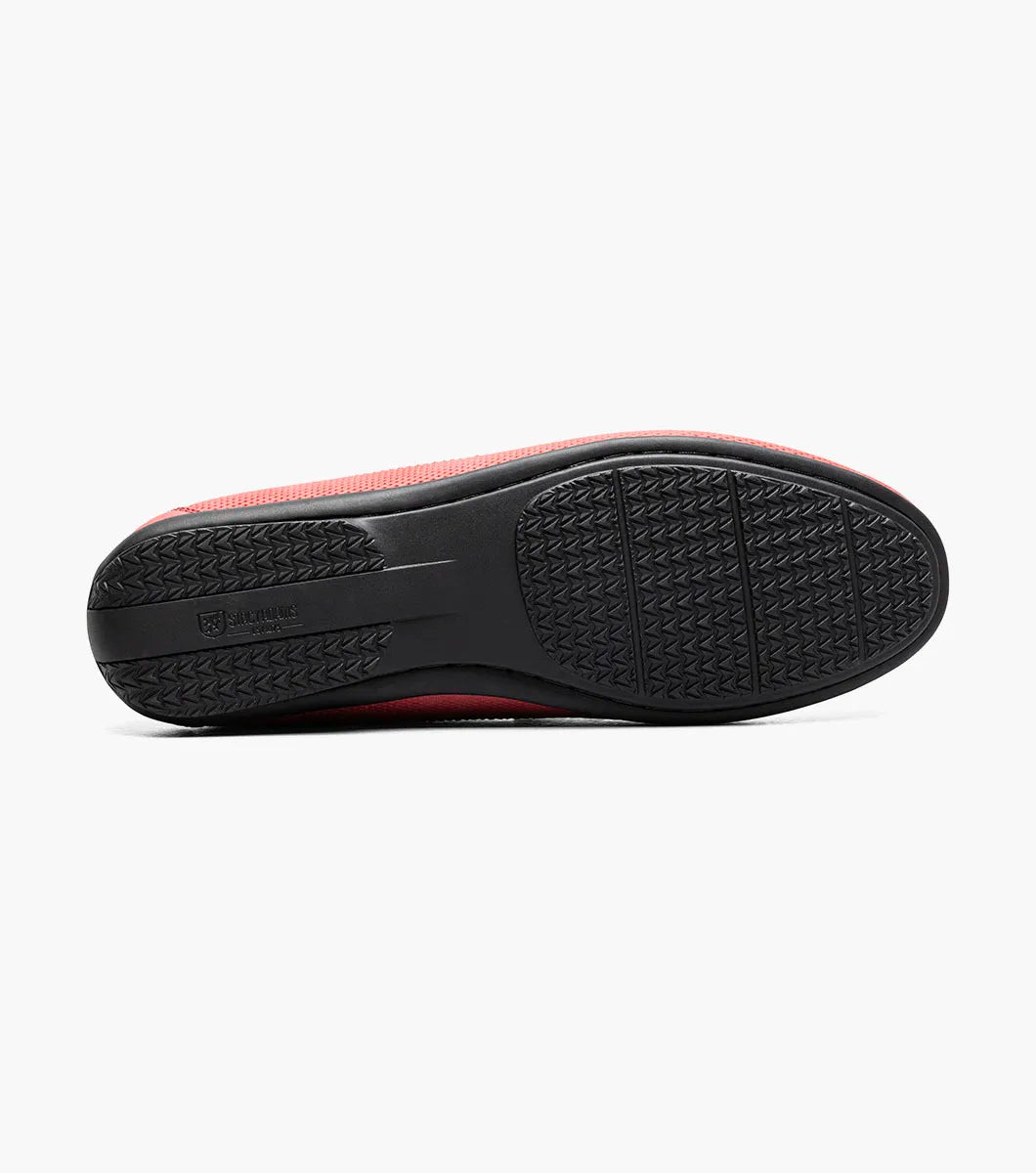 The Stacy Adams Colton Moc Toe Bit Slip On (25760-600) is a red suede loafer featuring a metal bit detail, visible stitching, black sole, striped inner lining, and cushioned footbed for comfort.