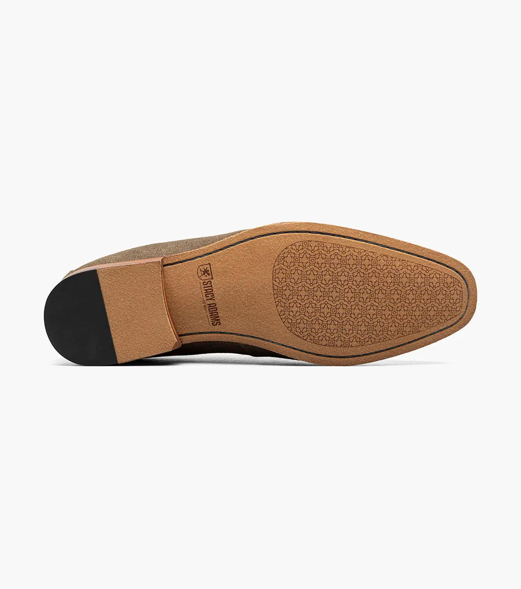 The Stacy Adams Gill Moc Toe Saddle Slip On in Mushroom Multi features a brown fabric upper, smooth leather strap and trim, low wooden heel, and moc toe design by STACY ADAMS. Product code: 25651-053. Displayed on a plain white background.