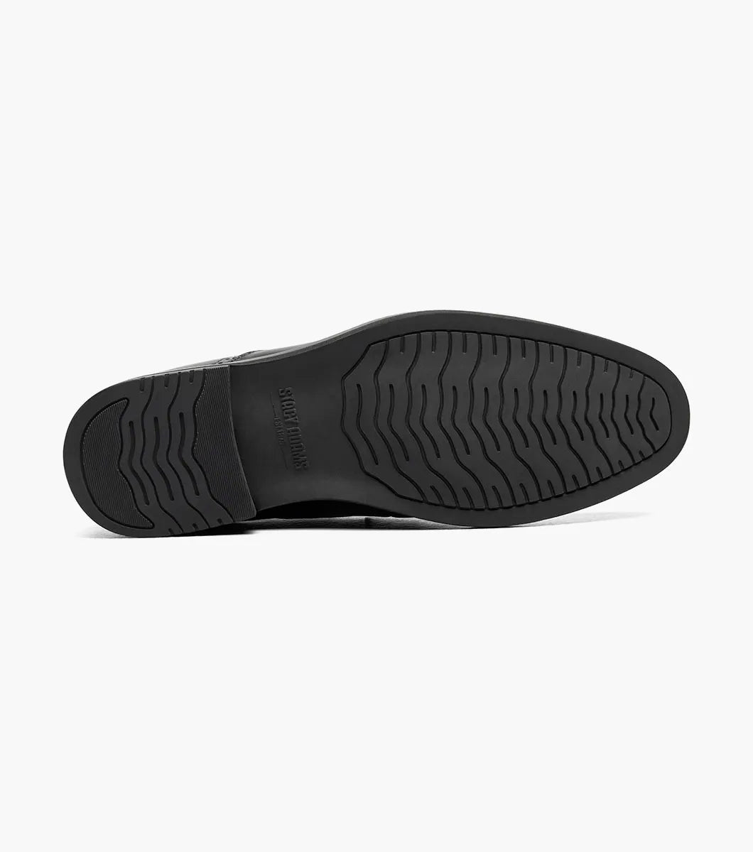The Stacy Adams Boyd Moc Toe Bit Slip On (Black, 25753-001) features a black leather loafer design with a metal bit detail, low heel, moc toe, visible stitching, and a cushioned footbed for comfort.