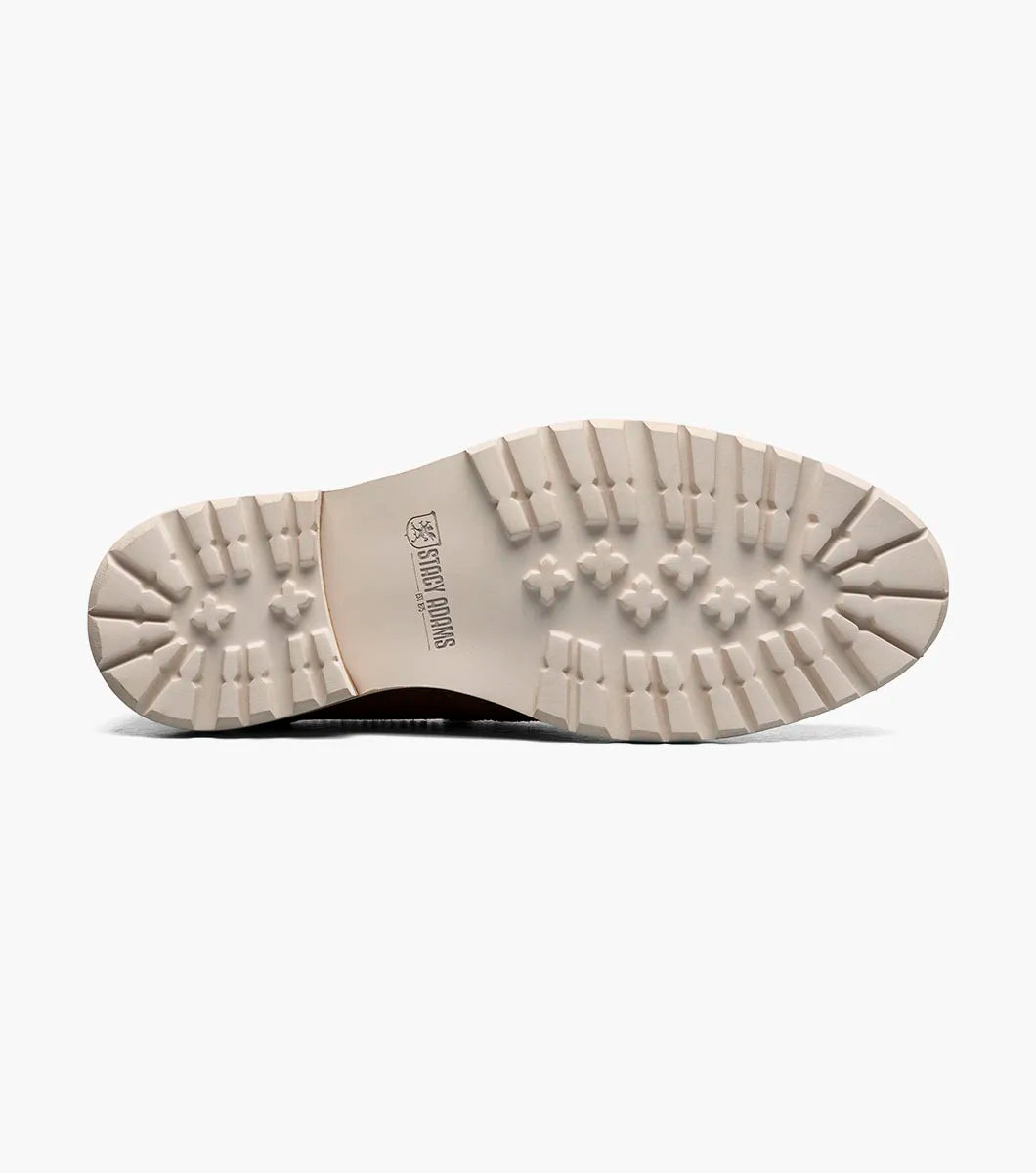 The STACY ADAMS Hopkins Moc Toe Penny Slip On in Sand (25708-269) is a light brown suede loafer with a white and tan rubber sole and red interior lining, shown on a white background.