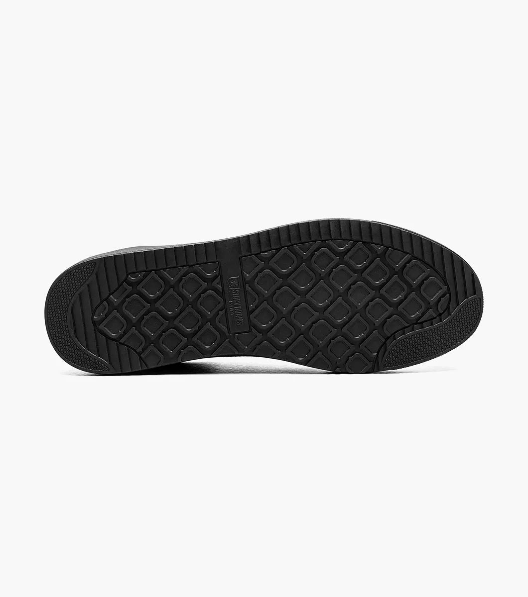 The Stacy Adams Dante Lace To Toe Sneaker in Black Smooth (Style 25806-005) features glossy patent leather and suede paneling, black laces, and a black rubber sole. Displayed on a white background, this STACY ADAMS low-top sneaker offers a sleek lace-to-toe design.