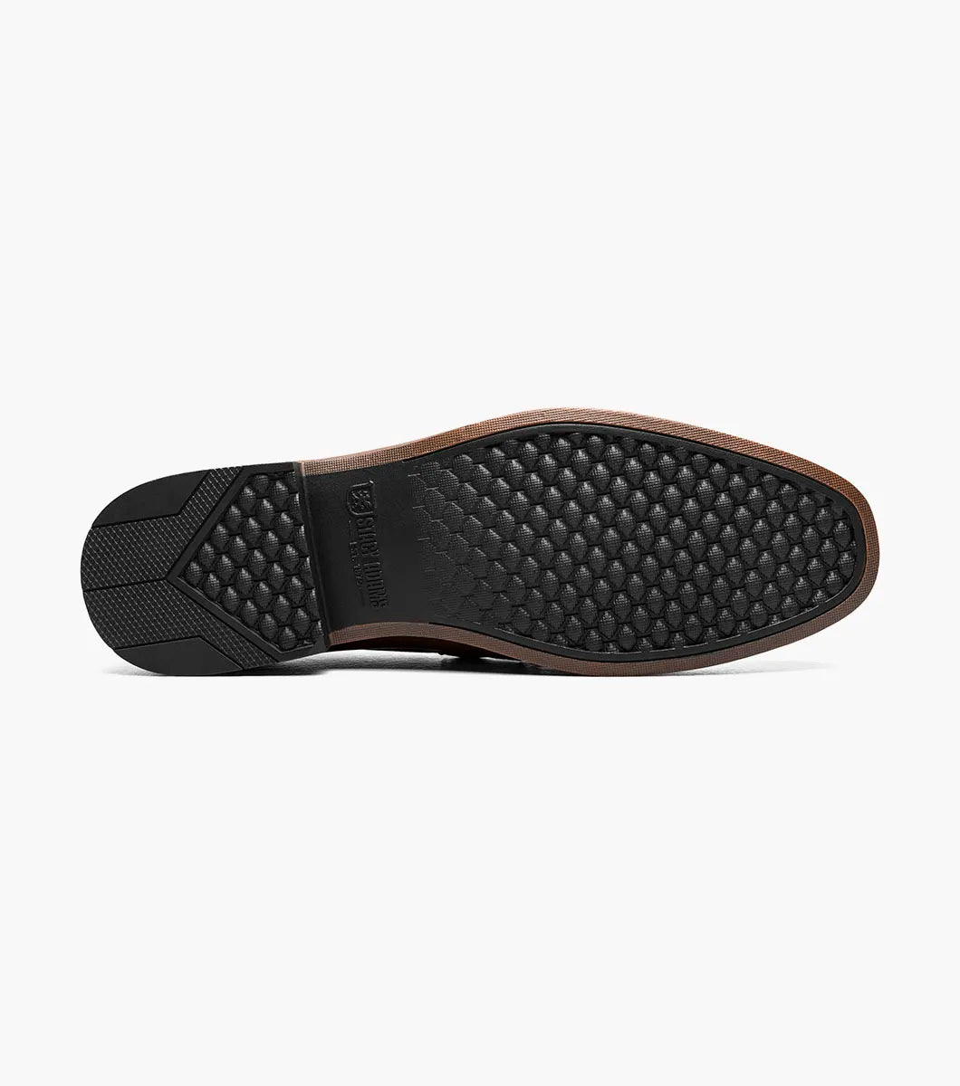 The STACY ADAMS Richmont Moc Toe Bit Slip On in Cognac Tumbled (21567-222) is a brown leather loafer with a metal bit, moc toe slip-on design, low wooden heel, and detailed toe stitching, shown on a white background.