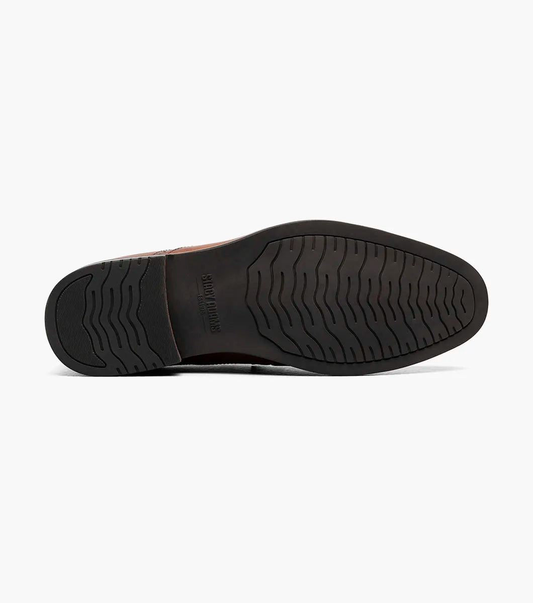 The Stacy Adams Boyd Moc Toe Bit Slip On in Brandy features a brown leather upper, moc toe design, metal horsebit detail, low heel, cushioned footbed, and visible stitching. Model 25753-226 by STACY ADAMS shown on a white background.