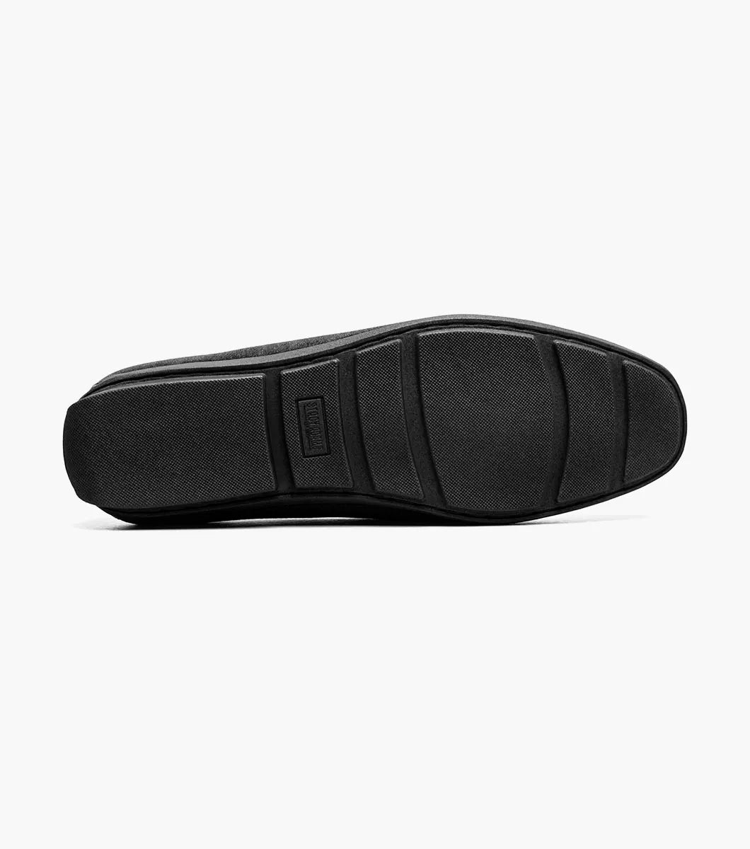 The Stacy Adams Sheridan Moc Toe Bit Slip On (black, 25761-001) is a sleek black suede dress shoe with braided detail and metal accent, low heel, and satin-lined interior for comfort.