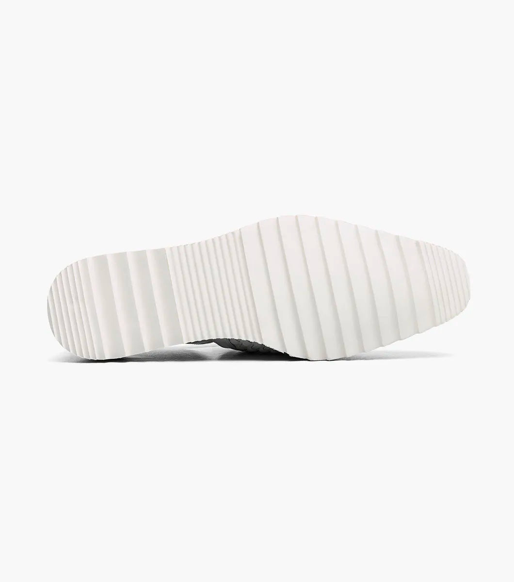 The Stacy Adams Alvarado Woven City Sandal in white features a woven leather upper, buckle strap, brown sole, white serrated outsole, and a soft memory foam insole for comfort. Displayed on a white background.