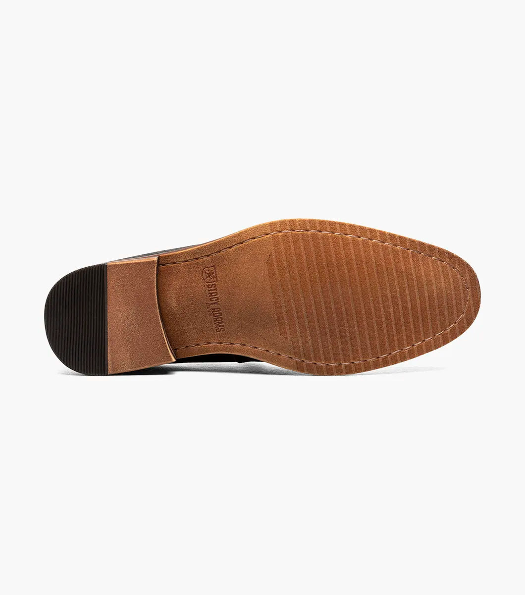 The Stacy Adams Prentice Moc Toe Slip On (25649-007) features black tumbled leather, a textured finish, brown wooden heel, and thin brown sole; shown on a white background.