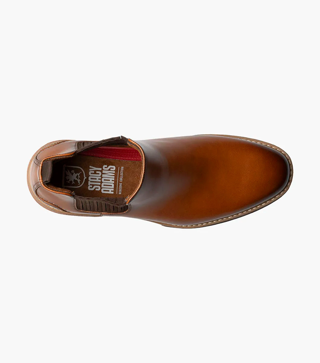 The Stacy Adams Platt Plain Toe Chelsea Boot in cognac features elastic side panels, a back pull tab, low stacked heel, and a RedZone removable footbed; shown on a white background.