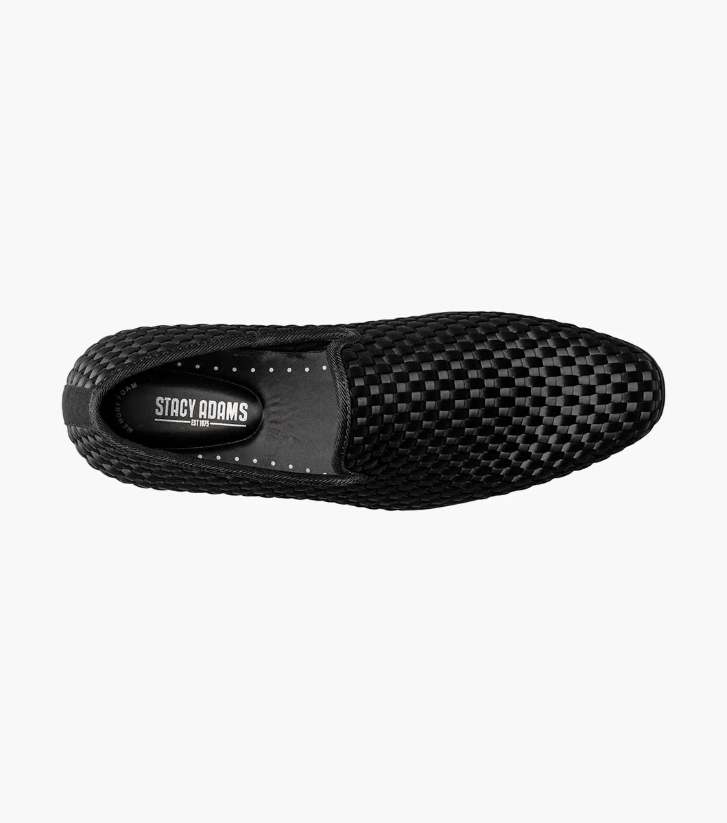 The STACY ADAMS Swenson Woven Slip On in black (25697-001) is a woven leather loafer featuring a low heel and cushioned insole, shown against a white background.