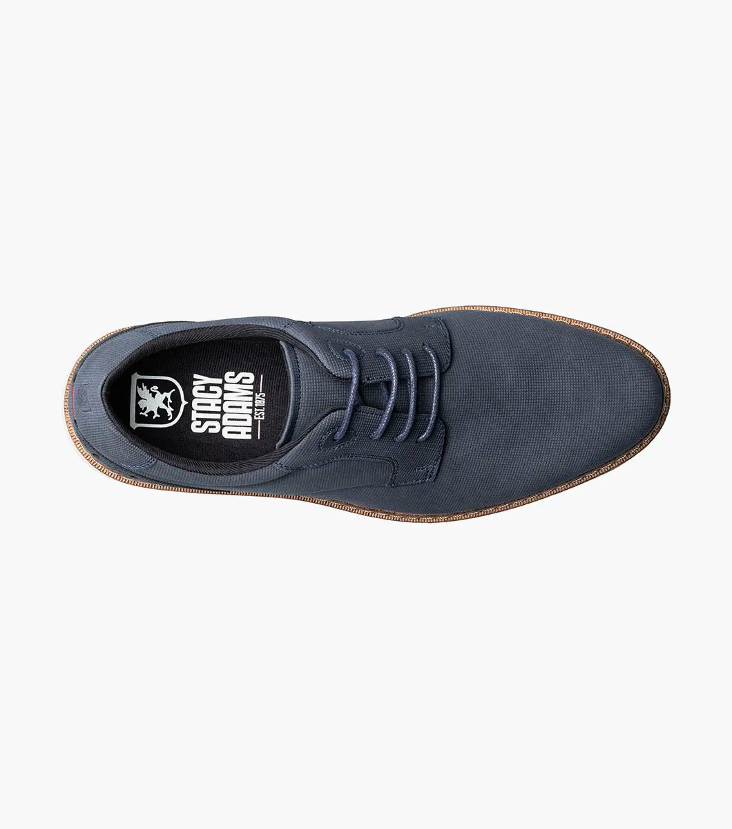 The STACY ADAMS Skyler Plain Toe Oxford in navy (style 21532-410) is a casual lace-up shoe crafted from man-made suede, featuring a white sole, brown stitching along the edge, subtle side perforation details, and a cushioned insole for enhanced comfort.