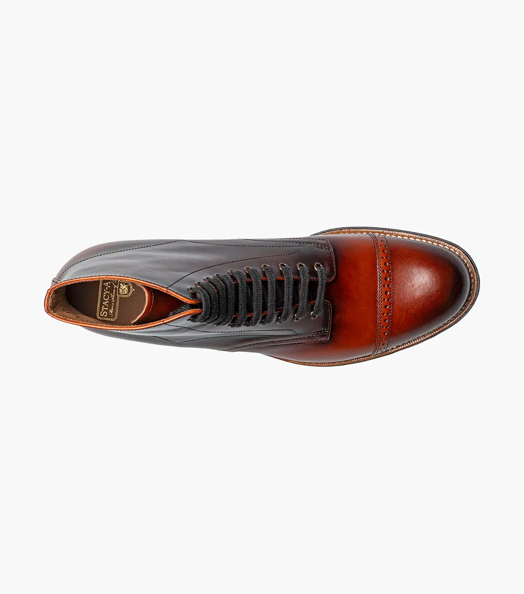 The Stacy Adams Madison Cap Toe Lace Up Boot in Cognac (00110-221) features brown leather, black laces, brogue detailing, and a stacked heel. This stylish STACY ADAMS boot is shown on a white background.