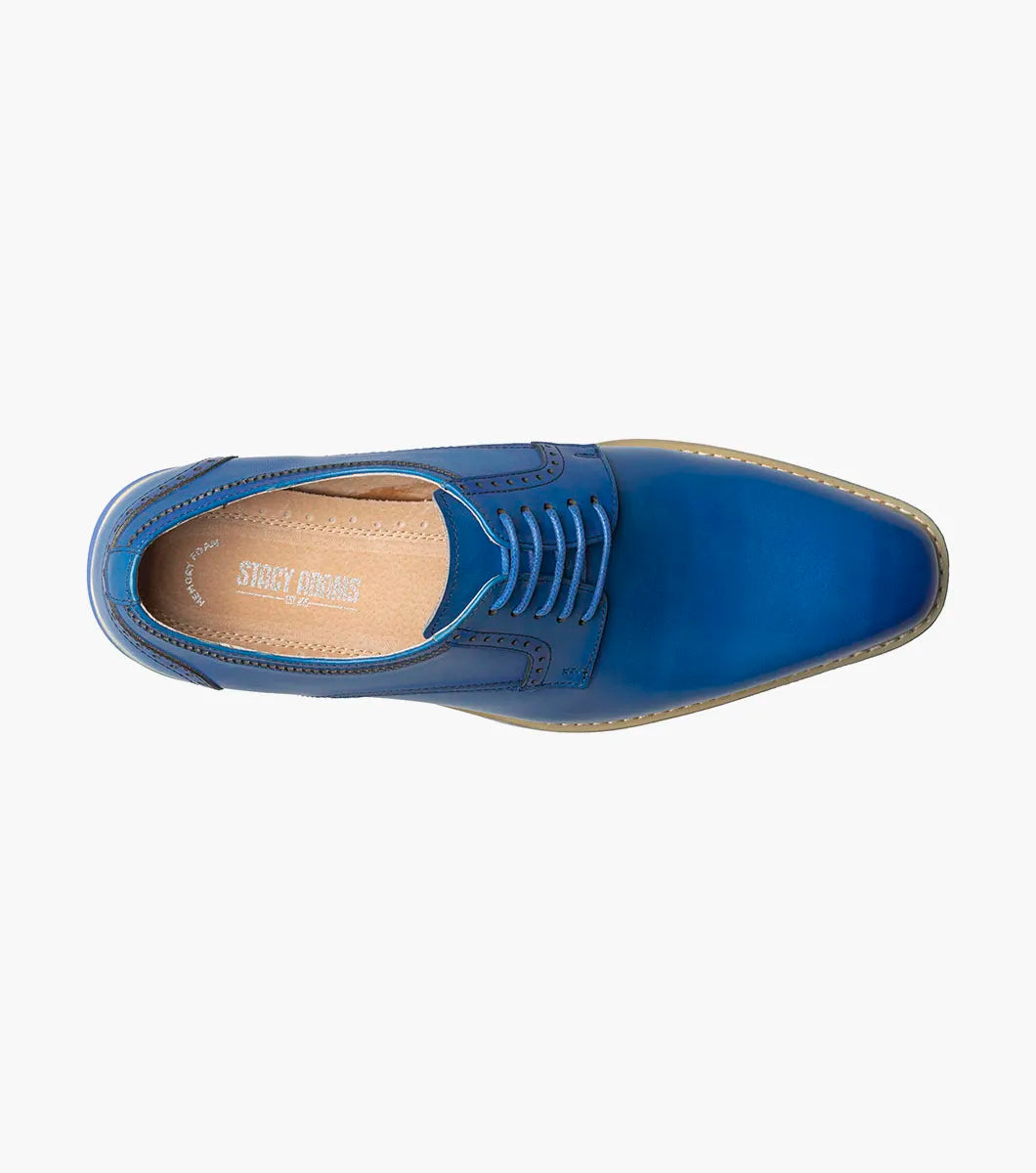 The Stacy Adams Barringer Plain Toe Oxford in blue features a leather upper with laces, a tan and white layered sole, durable rubber outsole, and subtle stitching details, shown in side view against a white background.