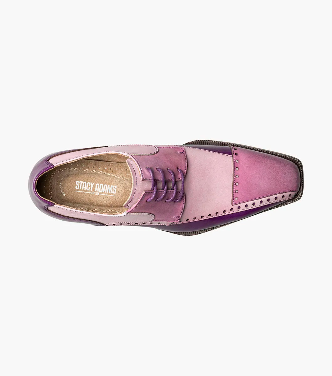 The STACY ADAMS Plaza Modified Cap Toe Oxford (25608-540) is a men's dress shoe featuring a pointed toe, leather upper in purple and pink gradient, decorative perforations, and a light brown sole.