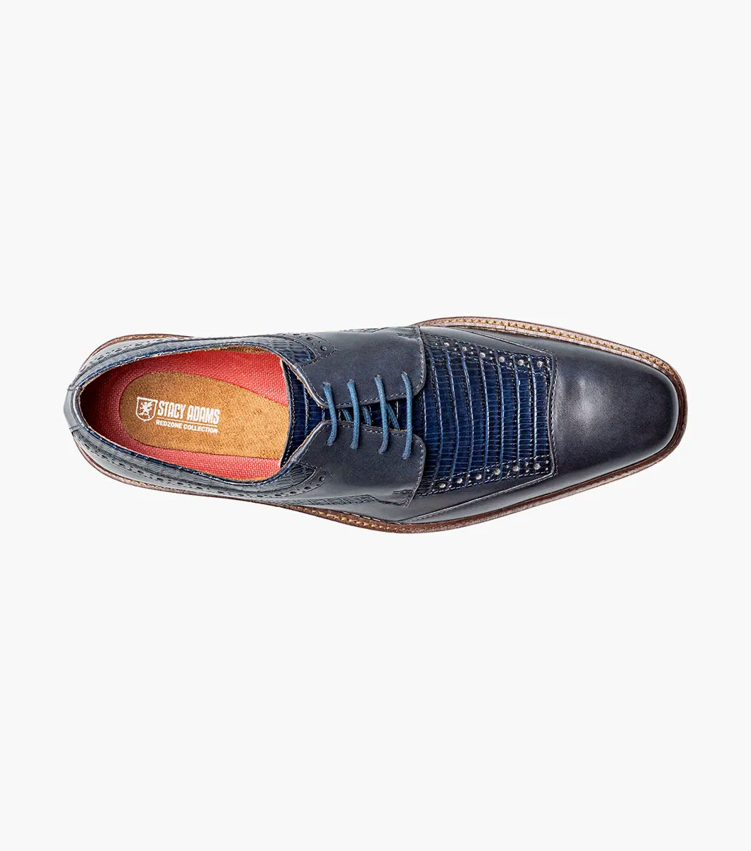 The STACY ADAMS Gambetta Modified Cap Toe Oxford (Navy, 25780-410) is a navy blue leather dress shoe featuring a textured pattern, brown sole, RedZone footbed, and lace-up closure, displayed on a white background.