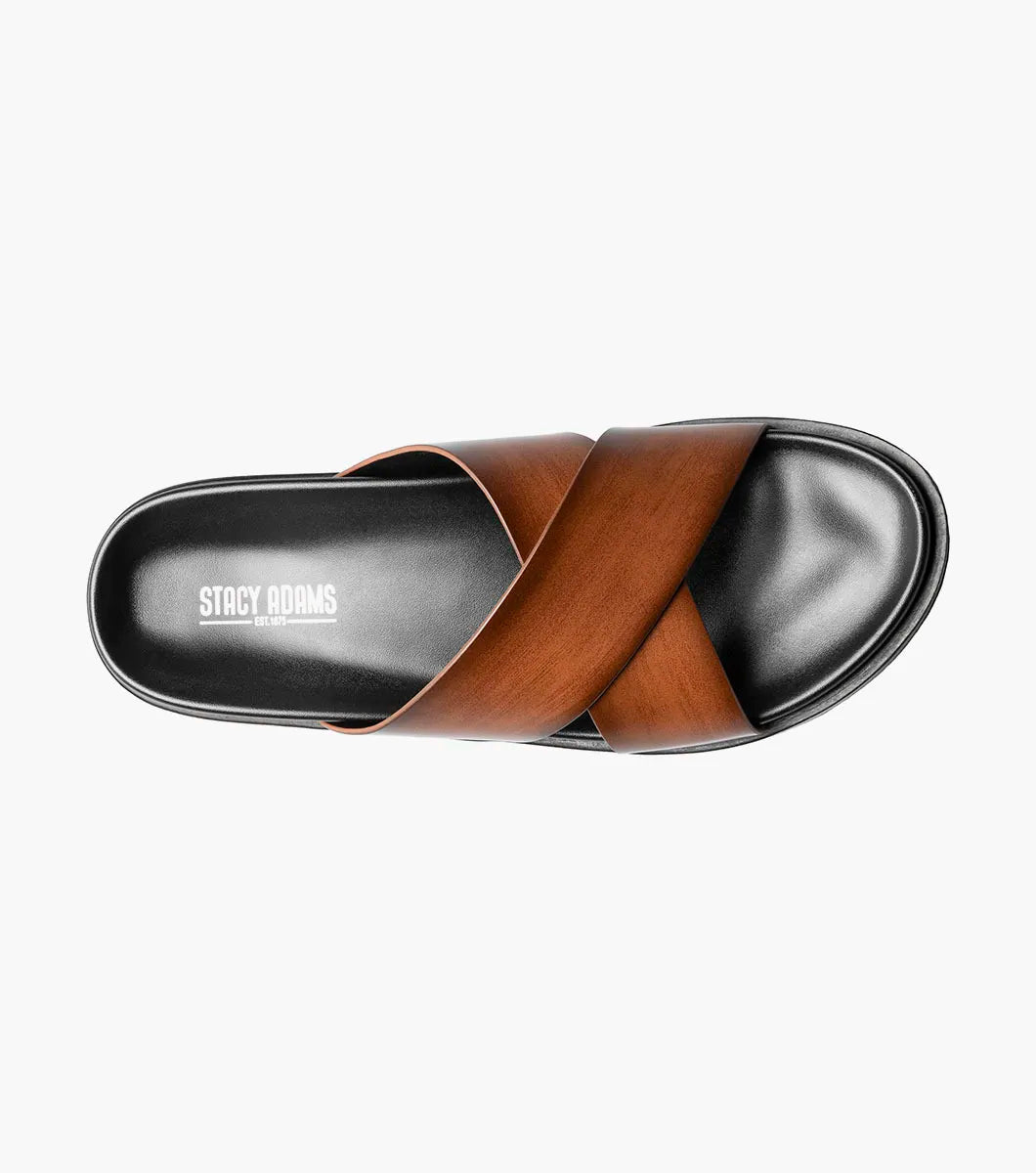 The Stacy Adams Montel Cross Strap Slide Sandal in Cognac (25469-221) features brown leather straps and a black cushioned footbed, perfect for summer. Shown on a white background.