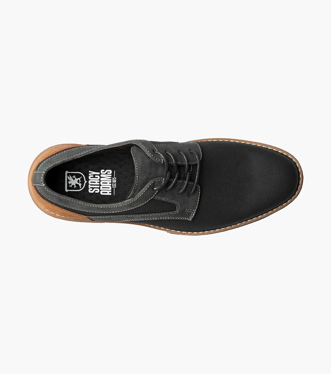 The Stacy Adams Phineas Plain Toe Oxford (25774-001) is a black lace-up oxford with textured material, gray stitching, a brown heel accent, and a cushioned insole for comfort, shown on a white background.