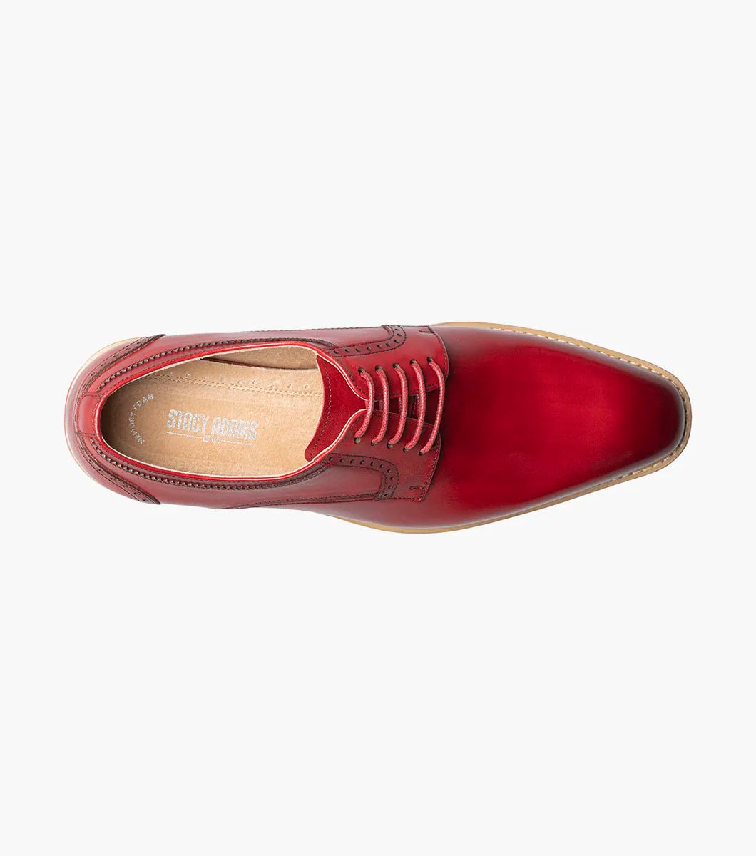 The Stacy Adams Barringer Plain Toe Oxford (25722-600) is a single red leather lace-up dress shoe with a leather upper, tan and white sole, and decorative stitching, shown on a white background.