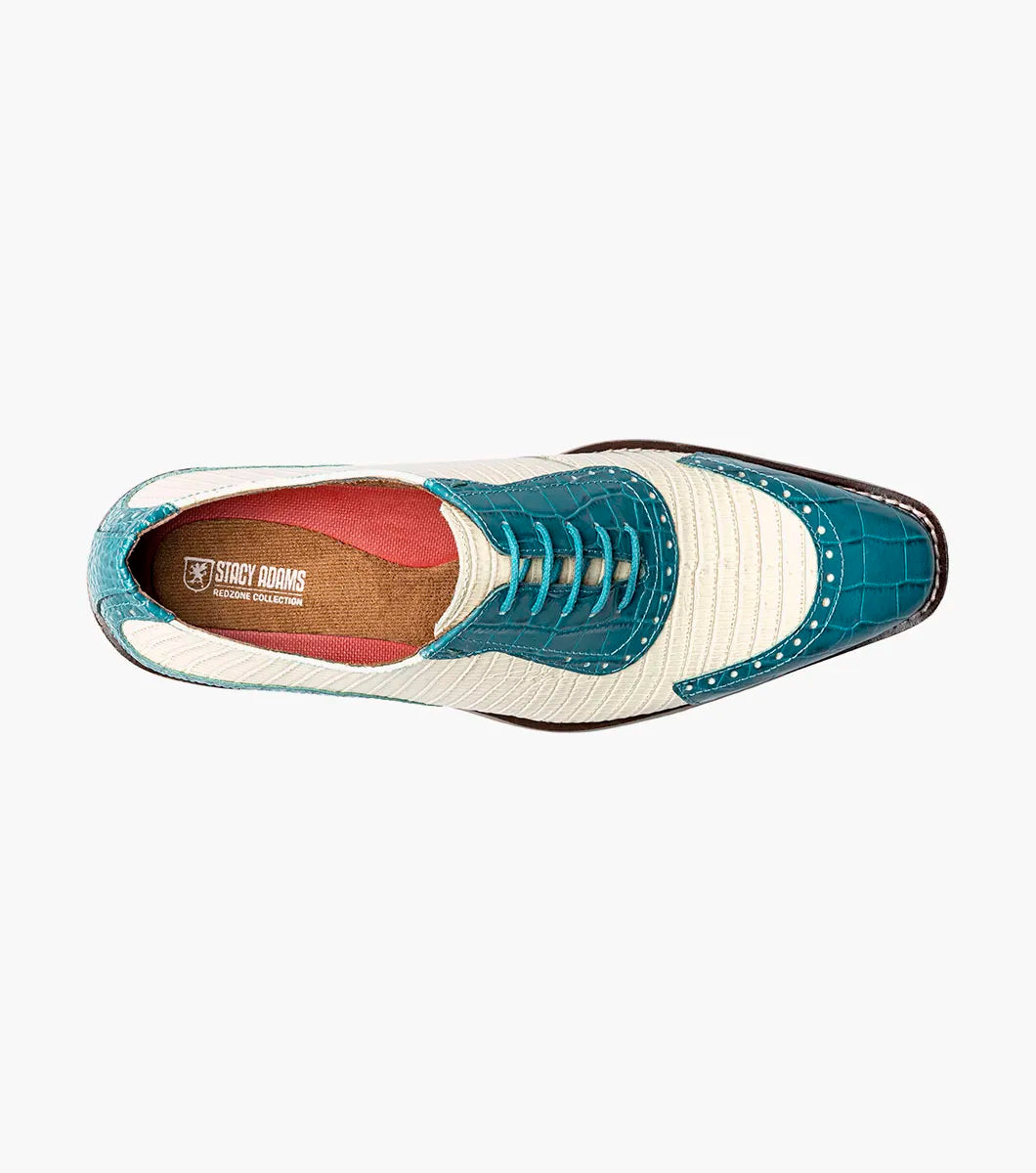 The STACY ADAMS Tarango Modified Cap Toe Oxford (25770-448) is a men's formal shoe in navy with teal, showcasing crocodile print leather and a laceless design, pictured on a plain white background.