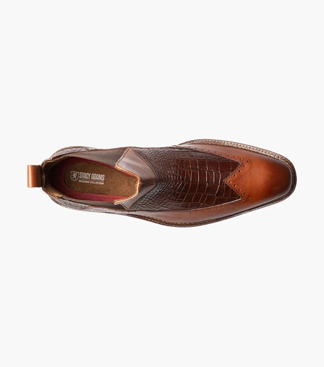 The Stacy Adams Garza Wingtip Chelsea Boot in Cognac features crocodile texture detail, elastic side panel, heel pull tab, cushioned footbed for comfort, and a low wooden sole.
