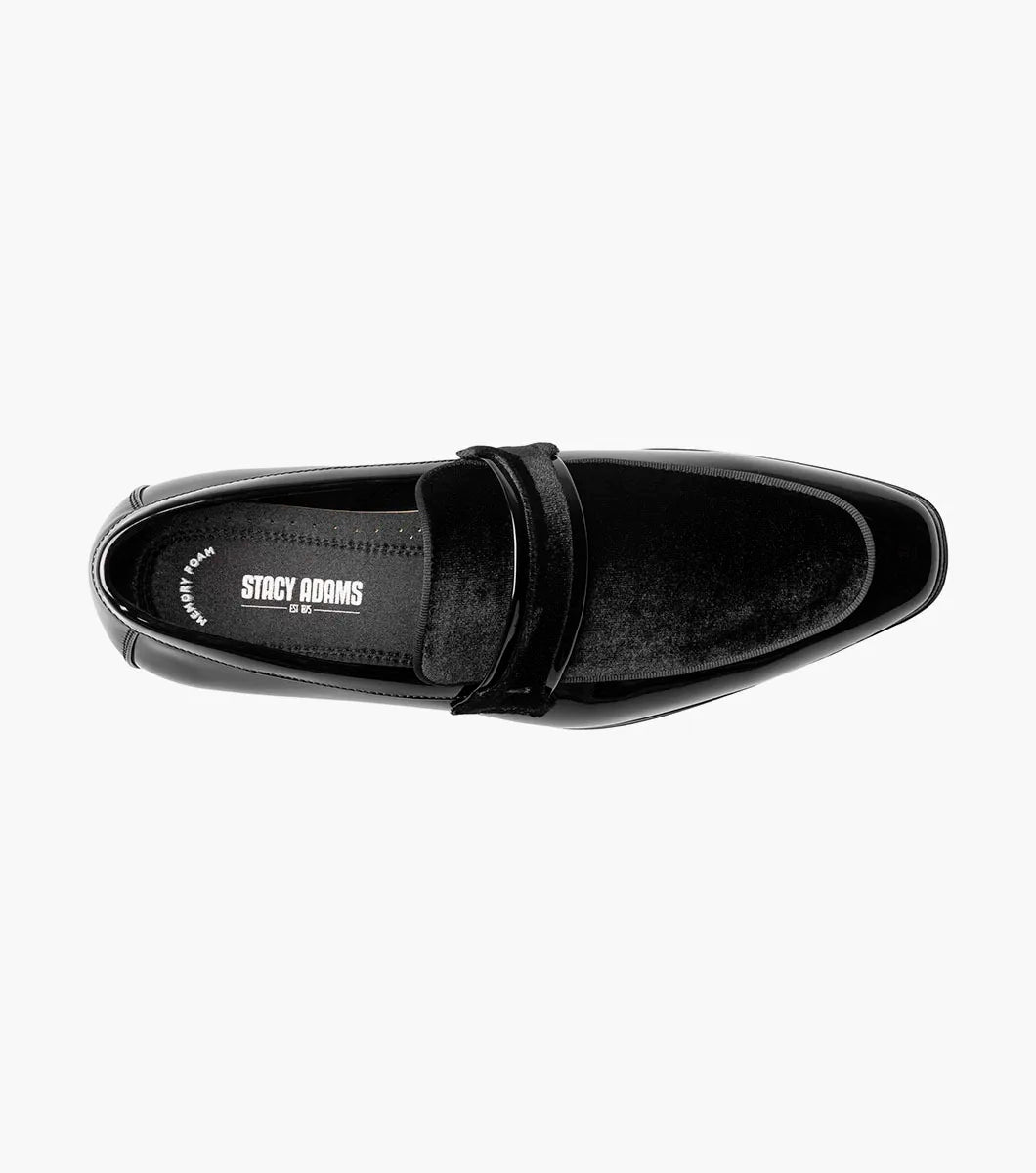 The STACY ADAMS Spratley Moc Toe Saddle Slip On in black features patent leather, a low heel, velvety strap detail, memory foam cushioning, and a slightly pointed toe, shown on a white background.