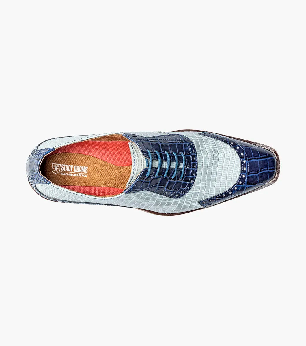 The Stacy Adams Tarango Modified Cap Toe Oxford in Dark Blue Multi features pointed toes, gray and blue crocodile print leather, and a low wooden heel—ideal for formal shoe enthusiasts.