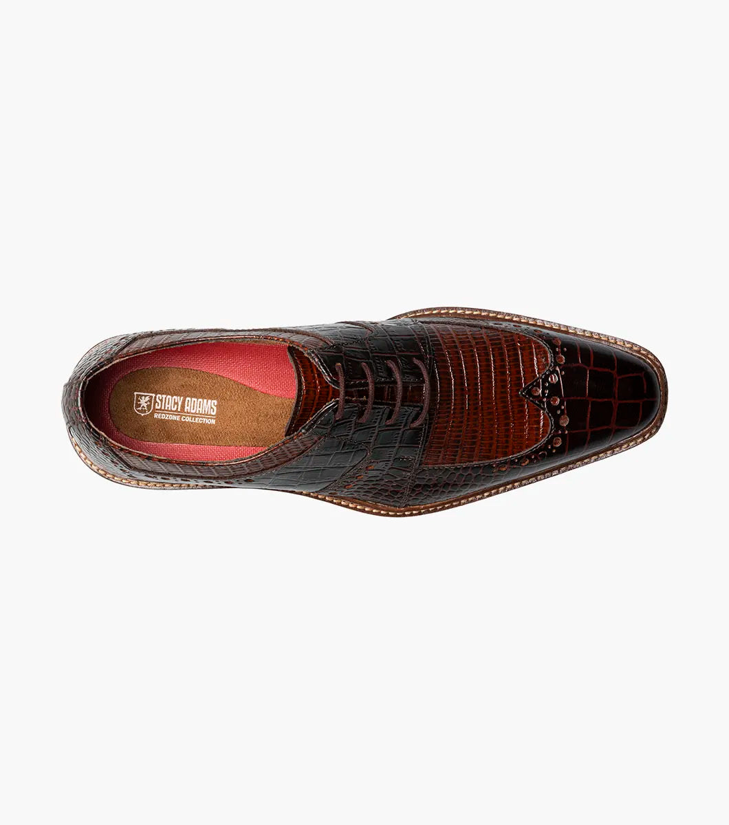 The STACY ADAMS Travato Wingtip Oxford (Brown Multi, 25737-249) features a crocodile-patterned leather upper, laces, and a wooden sole, shown at an angle on a plain white background.