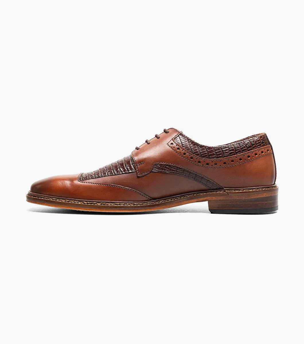 The Stacy Adams Gambetta Modified Cap Toe Oxford in cognac features textured detailing, lace-up closure, and a low heel, displayed on a white background.