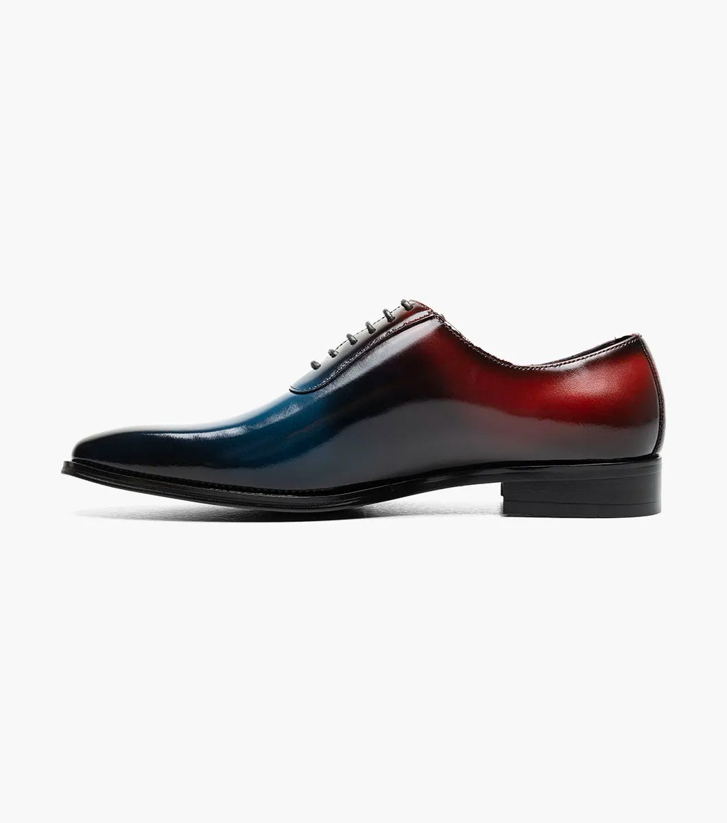 The STACY ADAMS Shaffer Plain Toe Oxford (Navy Multi, 25763-492) features premium calf leather with a gradient from deep red heel to blue toe, dark laces, and a black sole.