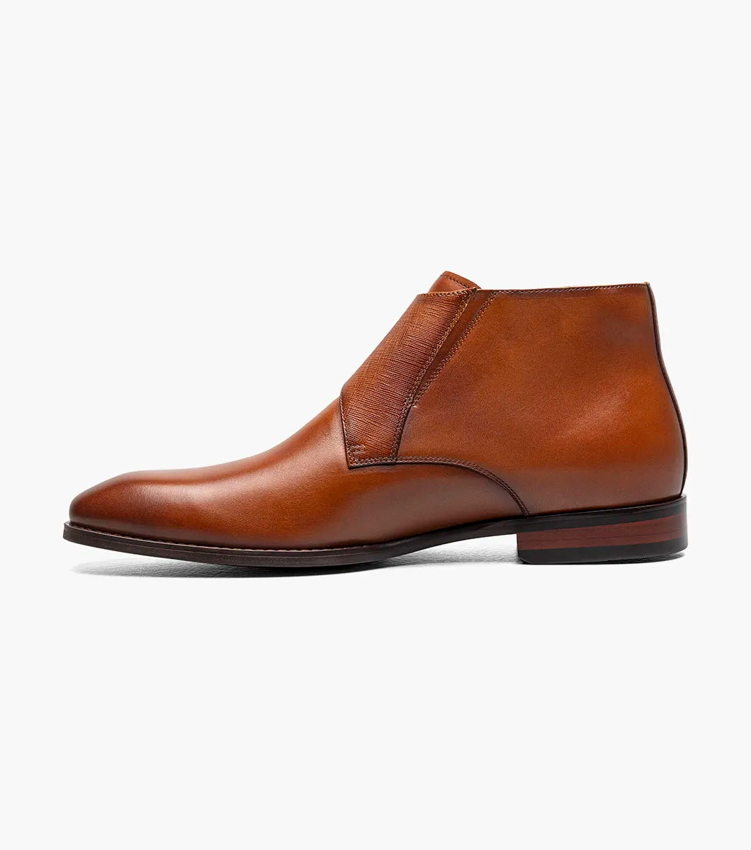 The STACY ADAMS Kaius Plain Toe Double Monk Strap Boot in Cognac (25733-221) features hand-burnished leather, a textured side panel, low stacked heel, and anatomical arch support, shown on a white background.