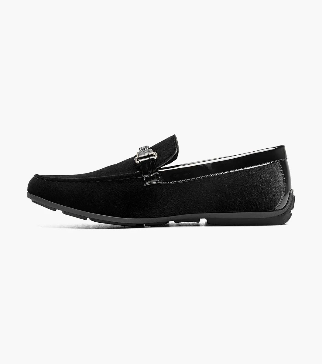 The Stacy Adams Sheridan Moc Toe Bit Slip On (black, 25761-001) is a sleek black suede dress shoe with braided detail and metal accent, low heel, and satin-lined interior for comfort.